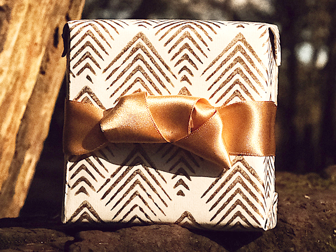 Present wrapped with premium wrapping paper with unique gold bow 